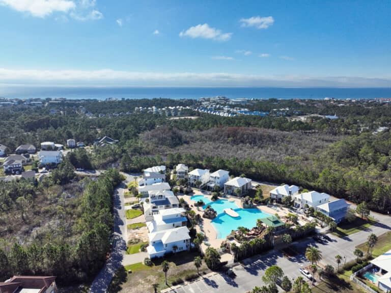 Aerial view of a Santa Rosa Beach neighborhood near Scenic Highway 30A showing coastal homes, preserved natural areas, and proximity to Florida's Emerald Coast shoreline.
